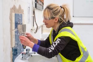 woman tiler being trained at The STC Group in Essex, construction training for women in Harold Wood and London, what is retrofit